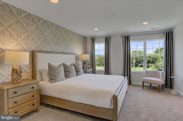 bedroom featuring multiple windows and light colored carpet