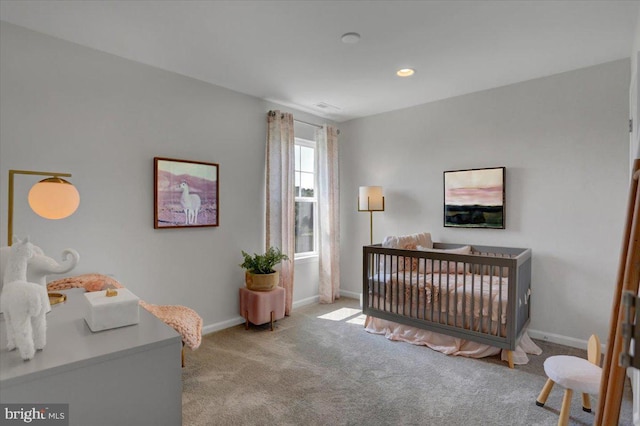 carpeted bedroom featuring a nursery area