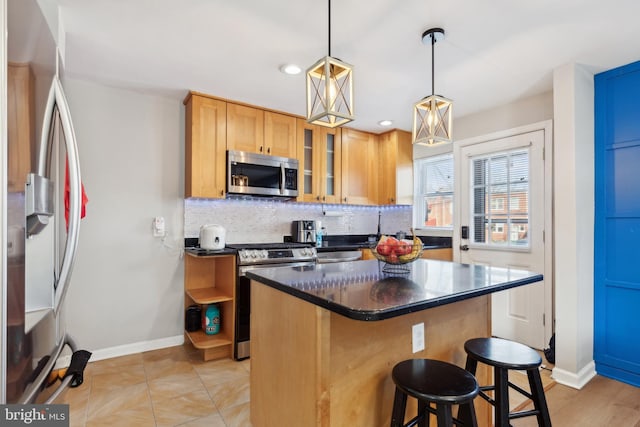 kitchen with a center island, hanging light fixtures, stainless steel appliances, decorative backsplash, and a breakfast bar