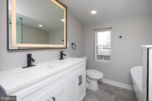 bathroom with a bath, vanity, and toilet