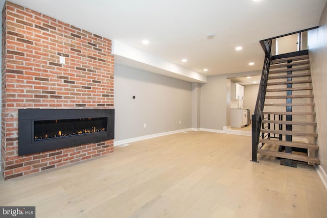 basement with hardwood / wood-style flooring and a fireplace