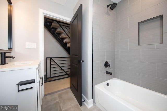 bathroom featuring tile patterned flooring, vanity, and tiled shower / bath