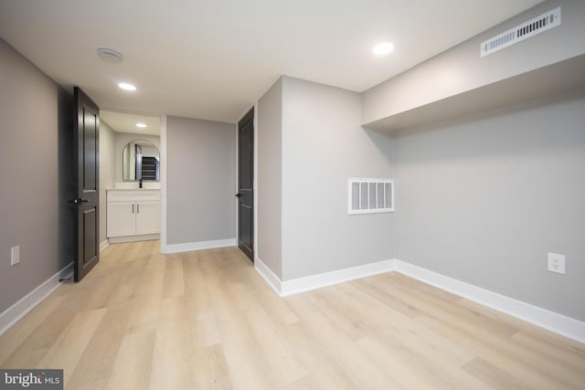 clothes washing area with light wood-type flooring