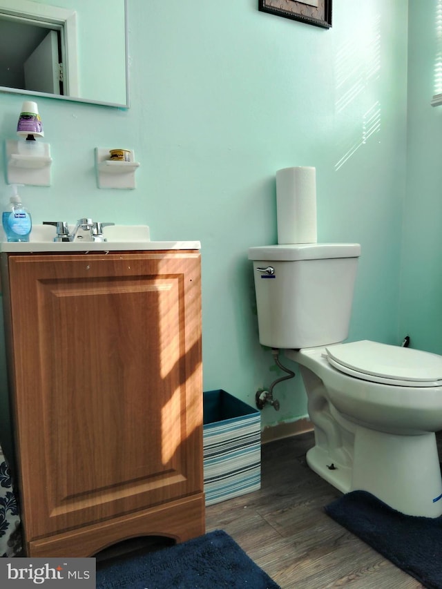 bathroom featuring toilet, vanity, and hardwood / wood-style flooring