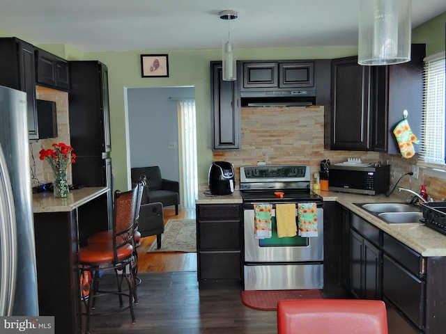 kitchen with sink, hanging light fixtures, dark hardwood / wood-style floors, tasteful backsplash, and stainless steel appliances