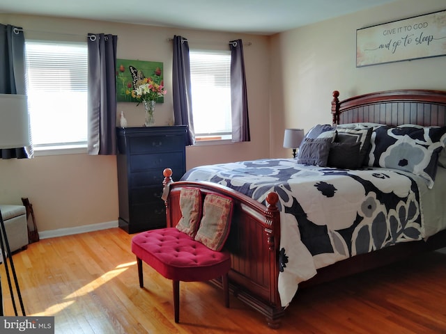 bedroom with hardwood / wood-style flooring and multiple windows