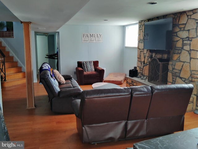 living room featuring hardwood / wood-style floors and a stone fireplace