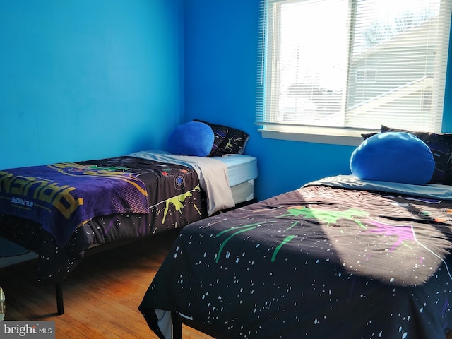 bedroom featuring hardwood / wood-style floors and multiple windows