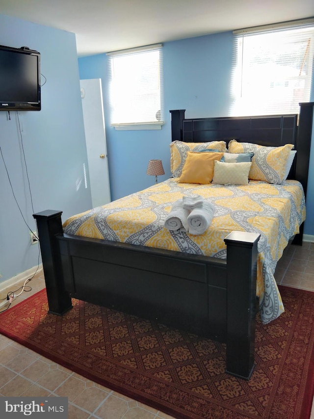 tiled bedroom featuring breakfast area and multiple windows