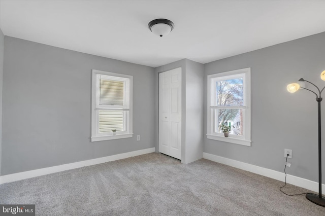 unfurnished bedroom with light colored carpet and a closet