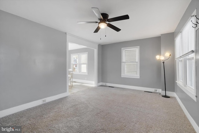 empty room featuring ceiling fan and light carpet