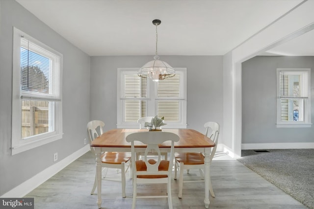 dining space with a chandelier and light hardwood / wood-style flooring