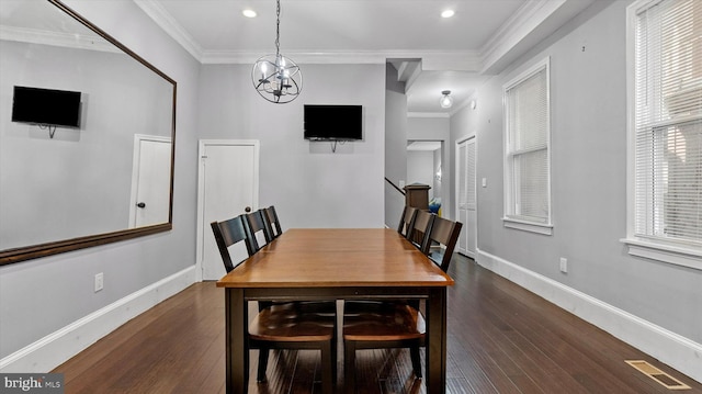 dining area with crown molding, dark wood-type flooring, and a notable chandelier