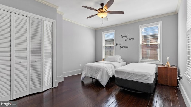 bedroom with ceiling fan, dark hardwood / wood-style flooring, crown molding, and a closet