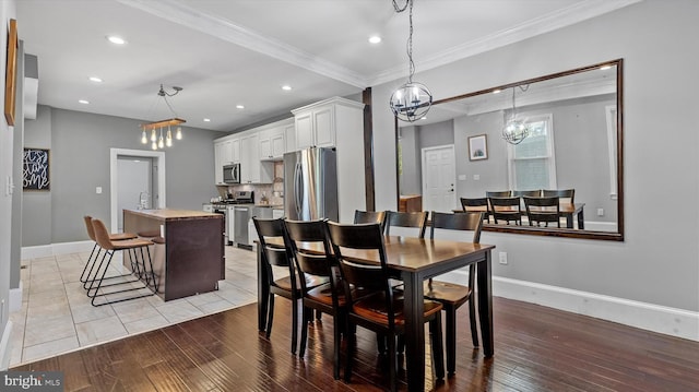 dining room with light hardwood / wood-style floors and ornamental molding