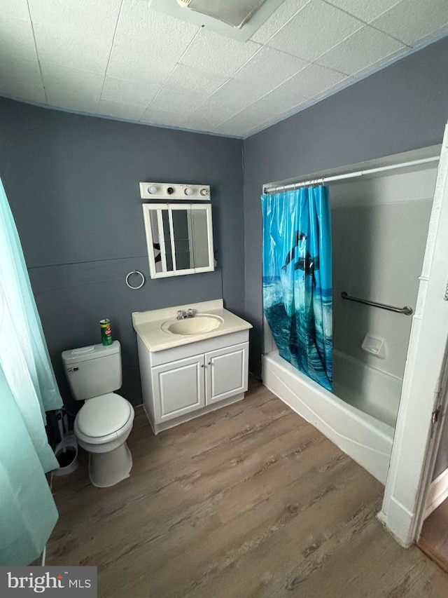 full bathroom featuring hardwood / wood-style floors, vanity, shower / bath combo, and toilet