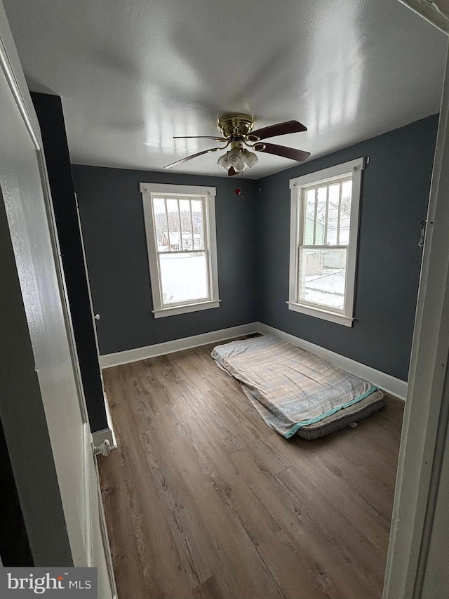 unfurnished bedroom with wood-type flooring and ceiling fan