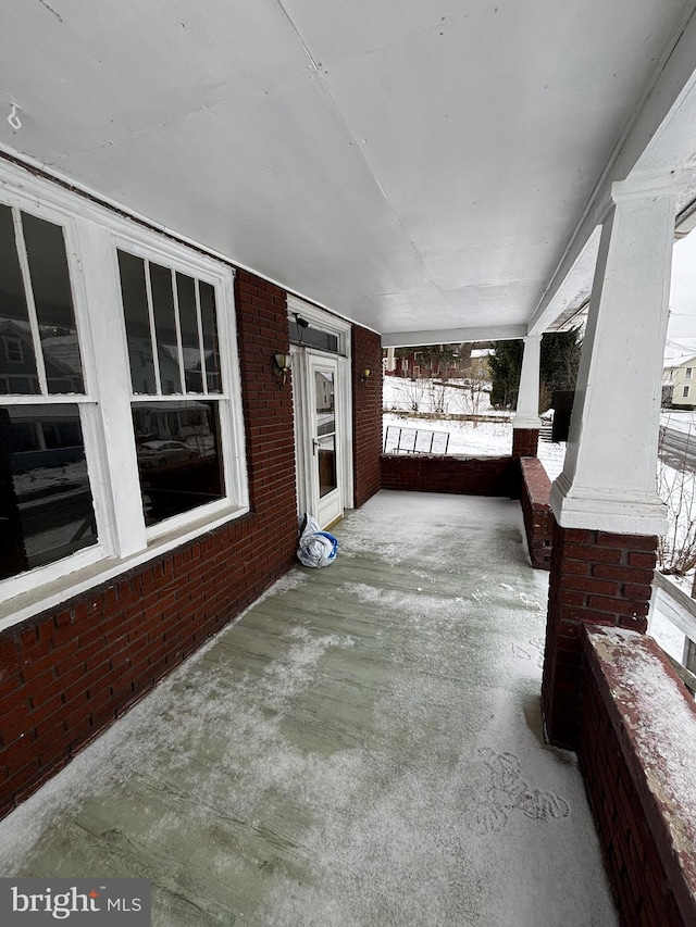 snow covered patio featuring a porch