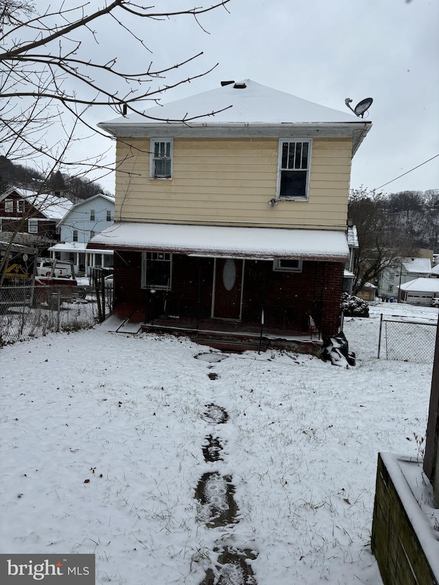 view of snow covered back of property