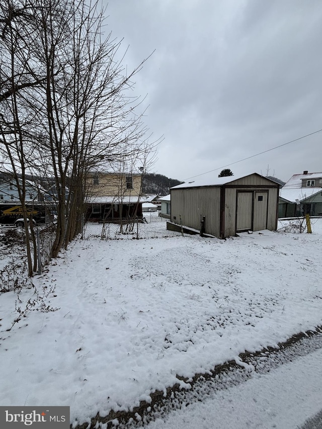 yard covered in snow featuring an outdoor structure