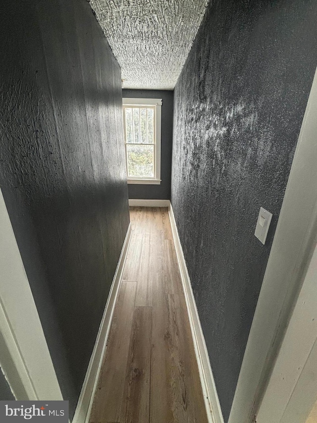 hall featuring hardwood / wood-style floors and a textured ceiling