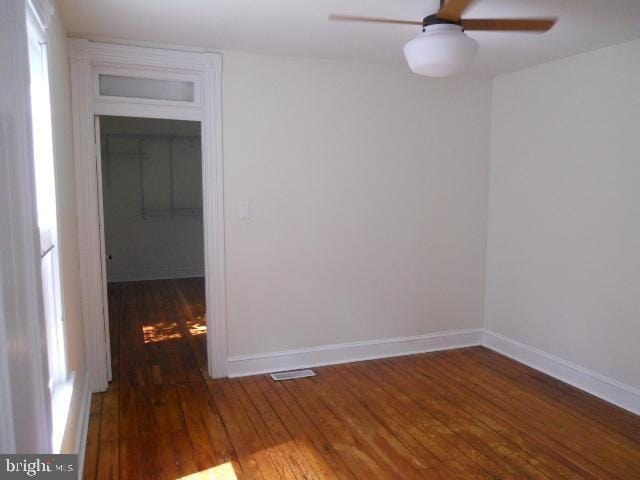 unfurnished room featuring ceiling fan and dark hardwood / wood-style flooring