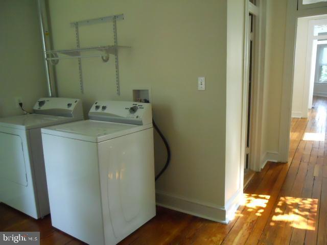 laundry area featuring separate washer and dryer and hardwood / wood-style flooring