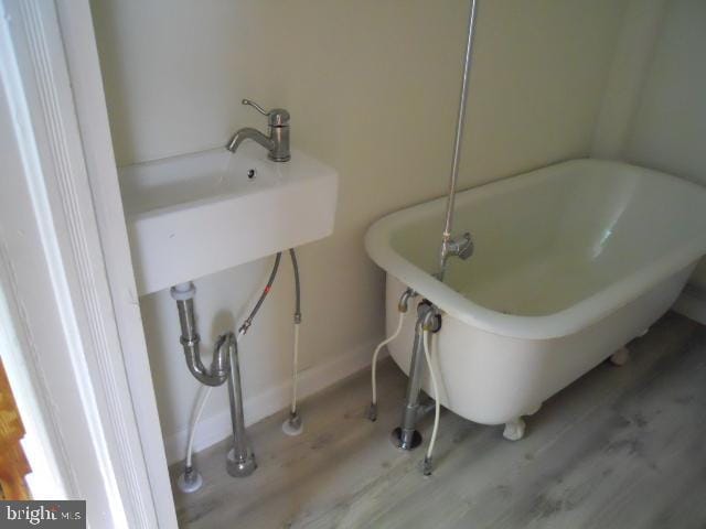 bathroom featuring a washtub and hardwood / wood-style floors