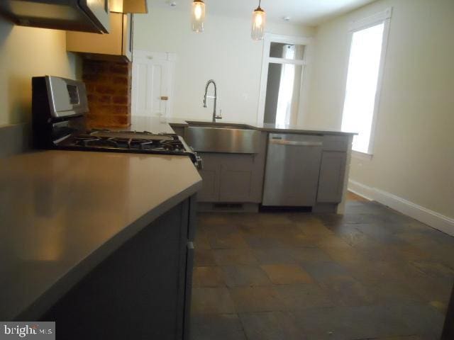 kitchen featuring stove, tasteful backsplash, gray cabinetry, sink, and dishwasher