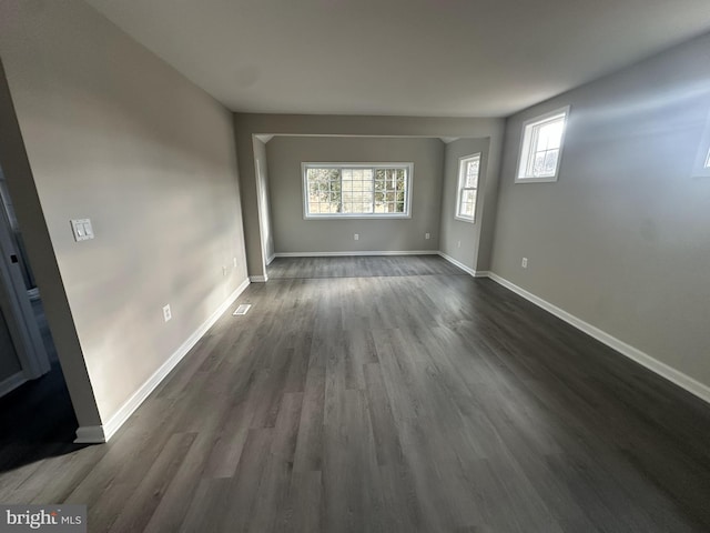 unfurnished room with dark wood-type flooring