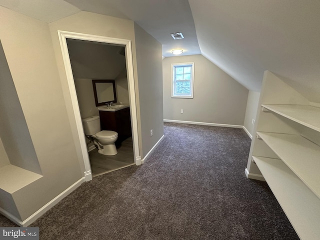 bonus room with dark carpet, lofted ceiling, and sink