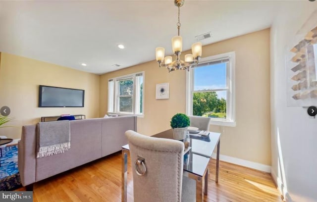 dining area featuring light hardwood / wood-style flooring and an inviting chandelier