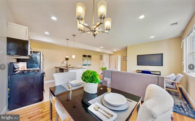 dining room featuring an inviting chandelier and light wood-type flooring