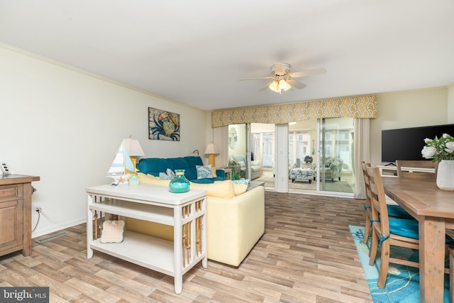 living room featuring crown molding, ceiling fan, and light hardwood / wood-style flooring