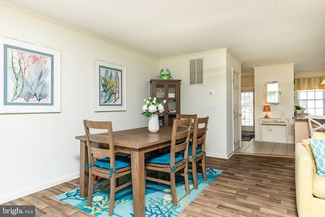 dining area featuring ornamental molding and wood-type flooring