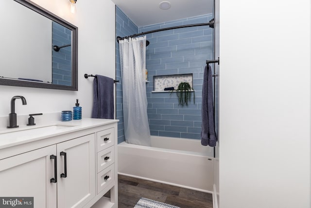 bathroom with hardwood / wood-style flooring, vanity, and shower / tub combo