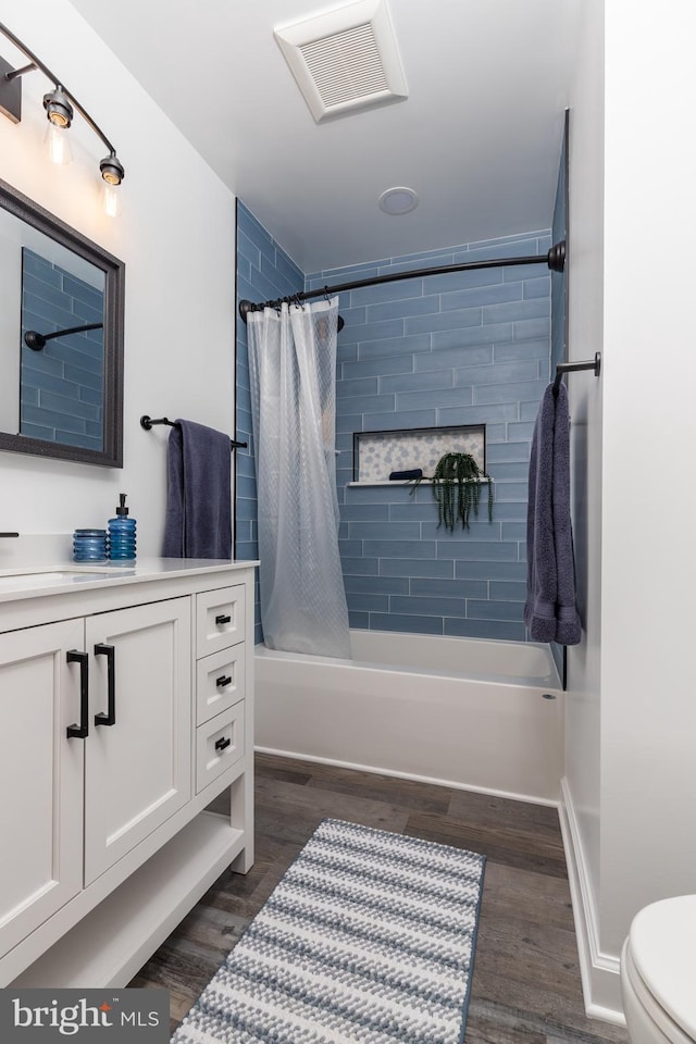 full bathroom featuring vanity, wood-type flooring, toilet, and shower / bath combo