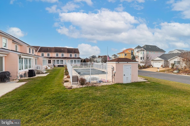 exterior space with a storage shed, a yard, and a swimming pool