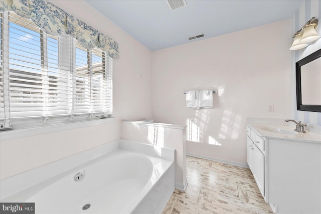 bathroom with a tub to relax in and vanity