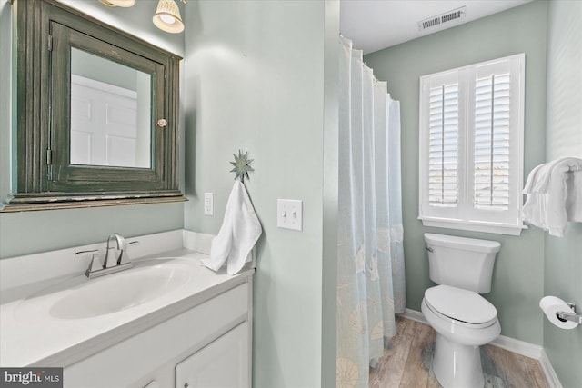 bathroom featuring vanity, hardwood / wood-style flooring, and toilet