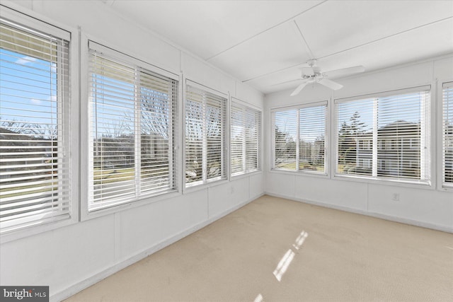 unfurnished sunroom featuring ceiling fan