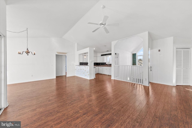 unfurnished living room with hardwood / wood-style flooring, ceiling fan with notable chandelier, and lofted ceiling