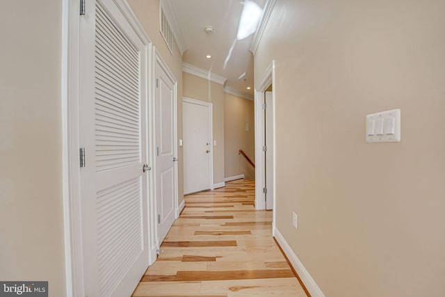 hallway featuring crown molding and light hardwood / wood-style flooring