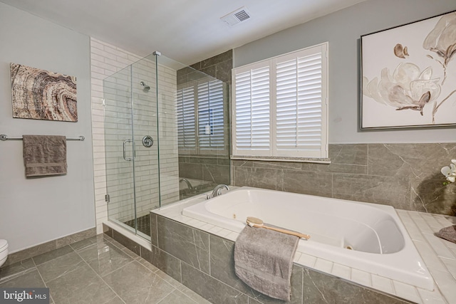 bathroom with tile patterned flooring, independent shower and bath, and toilet