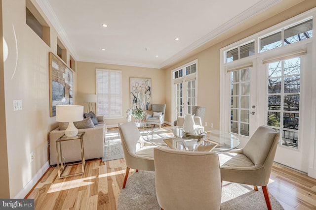 dining room with ornamental molding, light hardwood / wood-style flooring, and french doors