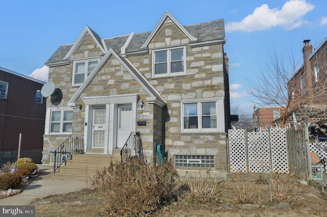 view of front of house featuring stone siding and a high end roof