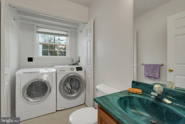 laundry area with separate washer and dryer and sink