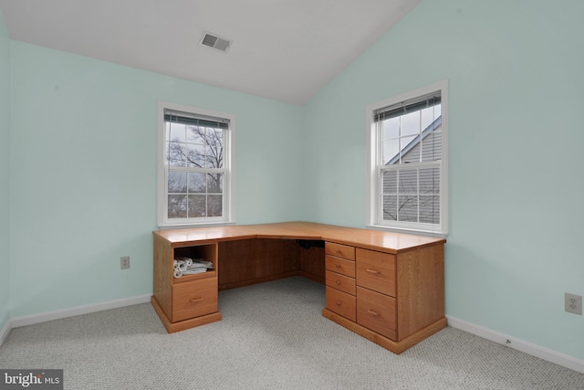 unfurnished office featuring light colored carpet and lofted ceiling