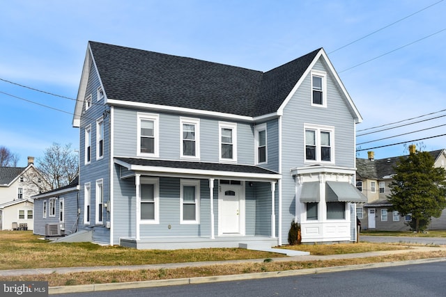 front of property with a front yard, cooling unit, and covered porch