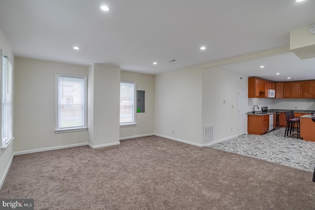 interior space featuring a breakfast bar, light stone counters, light carpet, electric range, and electric panel